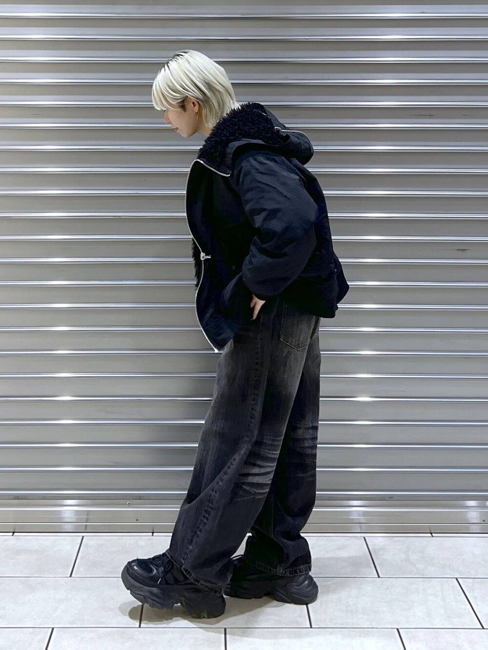 ブラック系のスニーカー、ブラック系のブルゾン、ブラック系のデニムパンツを着用したレディースの秋コーディネートの2枚目の写真