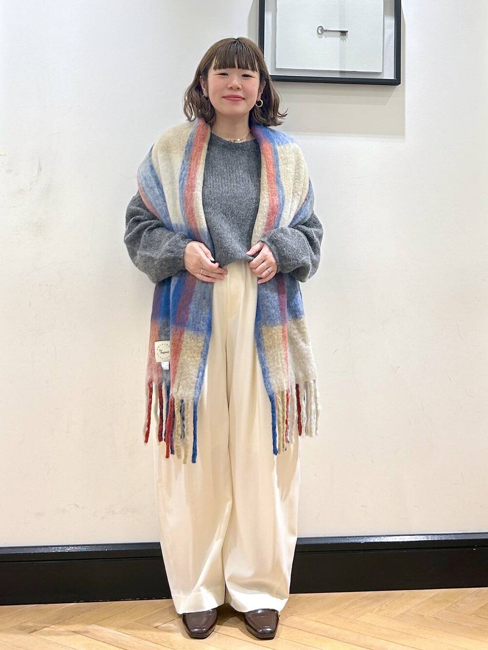 ホワイト系のスラックス、ブラウン系のローファー、グレー系のニット/セーターを着用したレディースの秋コーディネートの3枚目の写真