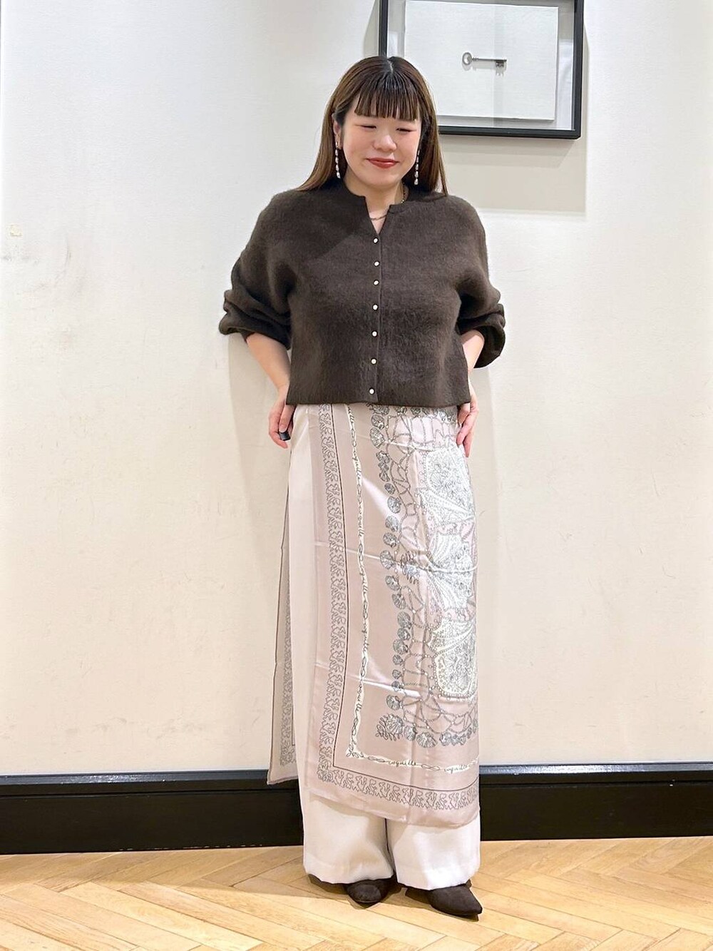 ブラウン系のカーディガン/ボレロ、ホワイト系のスラックス、ブラウン系のパンプスを着用したレディースの秋コーディネートの5枚目の写真