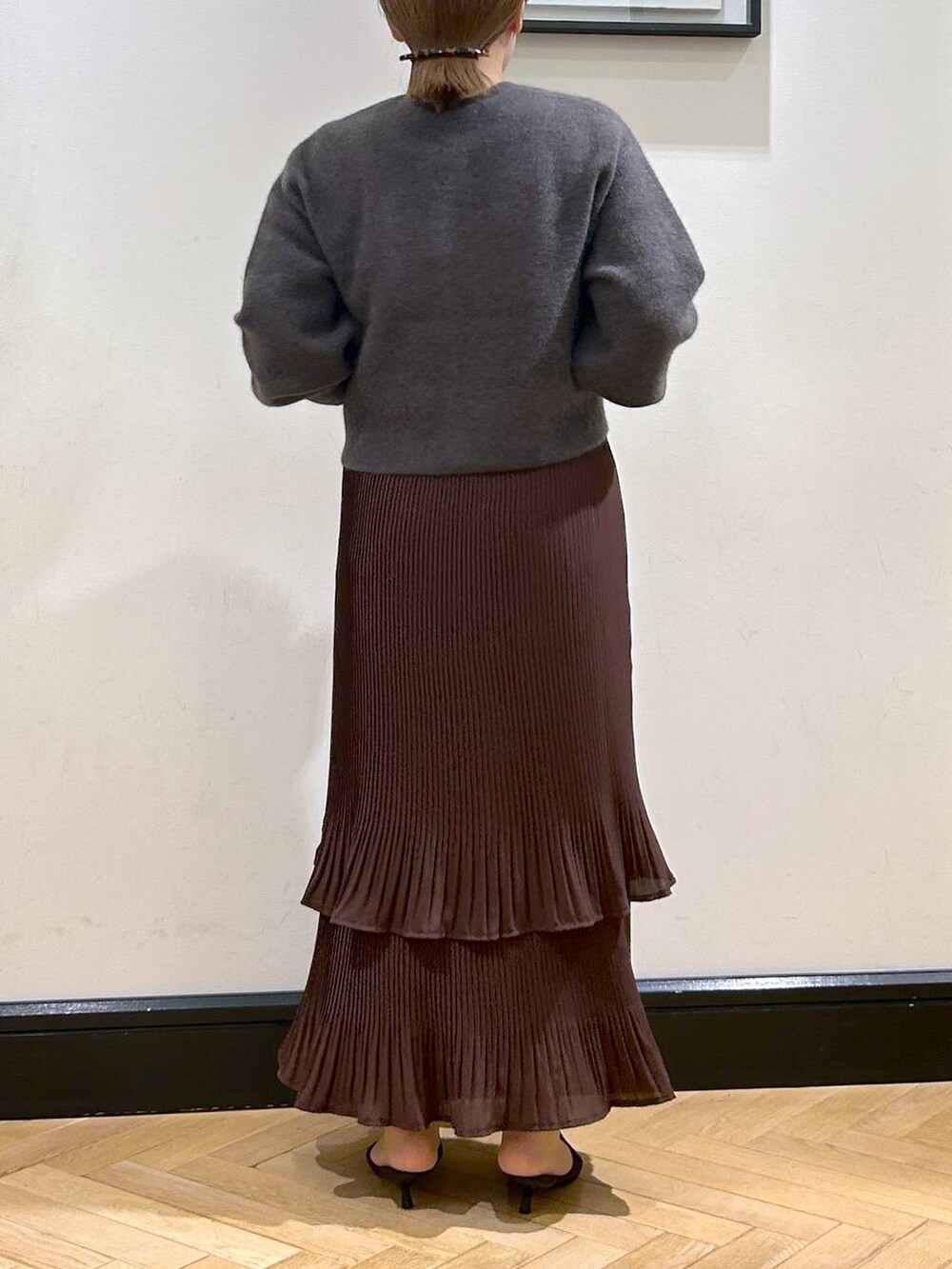 ブラウン系のスカート、グレー系のカーディガン/ボレロ、ブラウン系のパンプスを着用したレディースの秋コーディネートの6枚目の写真