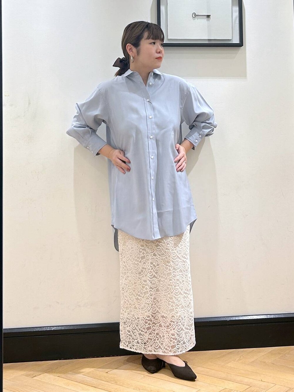 ブラウン系のパンプス、ホワイト系のスカート、ブルー系のシャツワンピースを着用したレディースの秋コーディネートの2枚目の写真