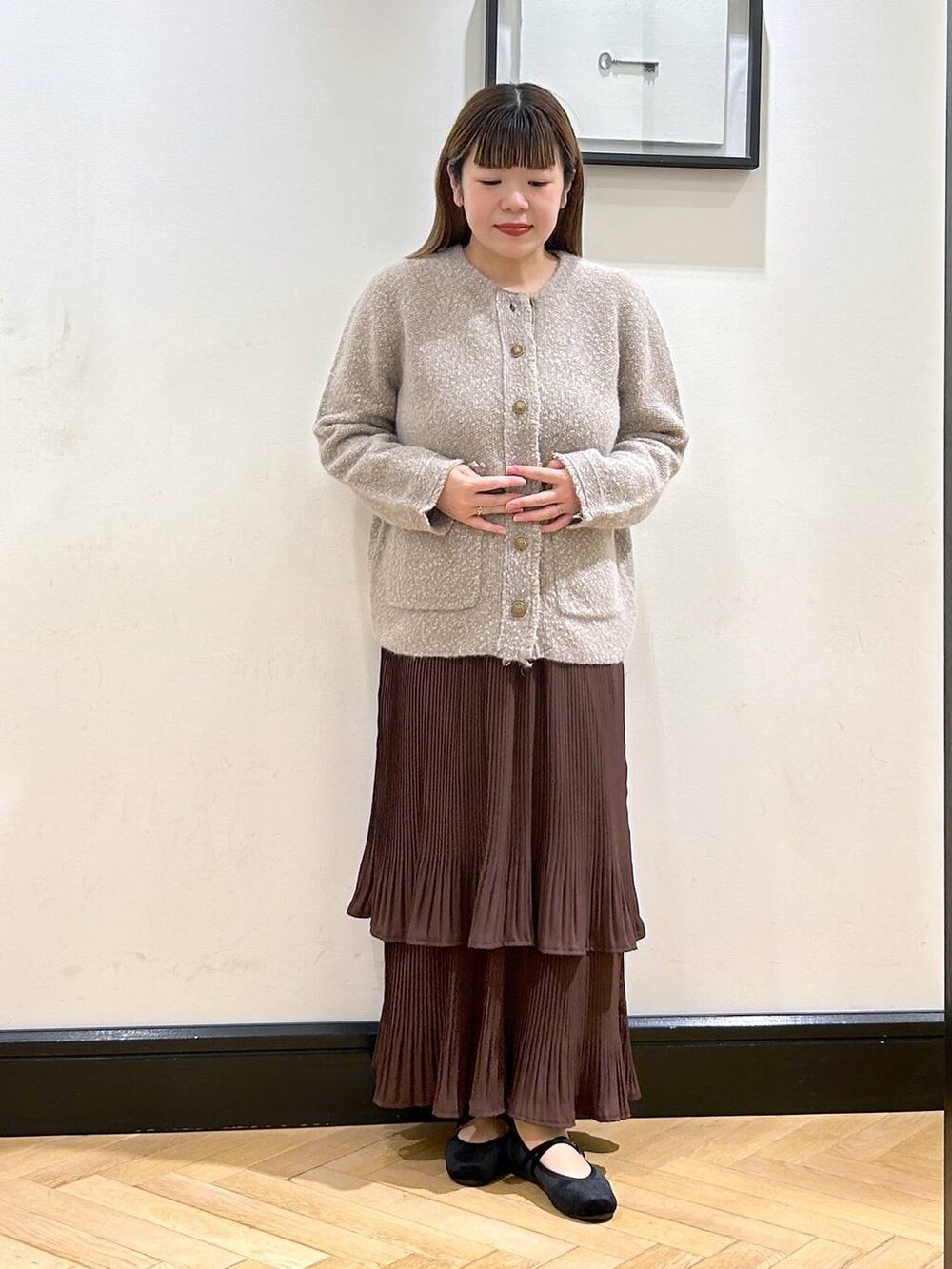 ブラウン系のスカート、ベージュ系のカーディガン/ボレロ、ブラック系のバレエシューズを着用したレディースの秋コーディネートの3枚目の写真