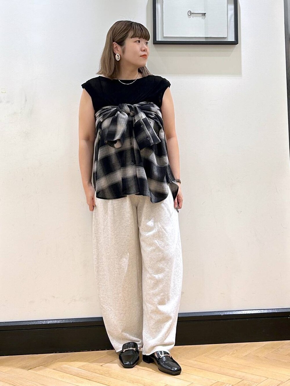 ブラック系のローファー、グレー系のスウェットパンツ、ブラック系のTシャツ/カットソーを着用したレディースの夏コーディネートの3枚目の写真