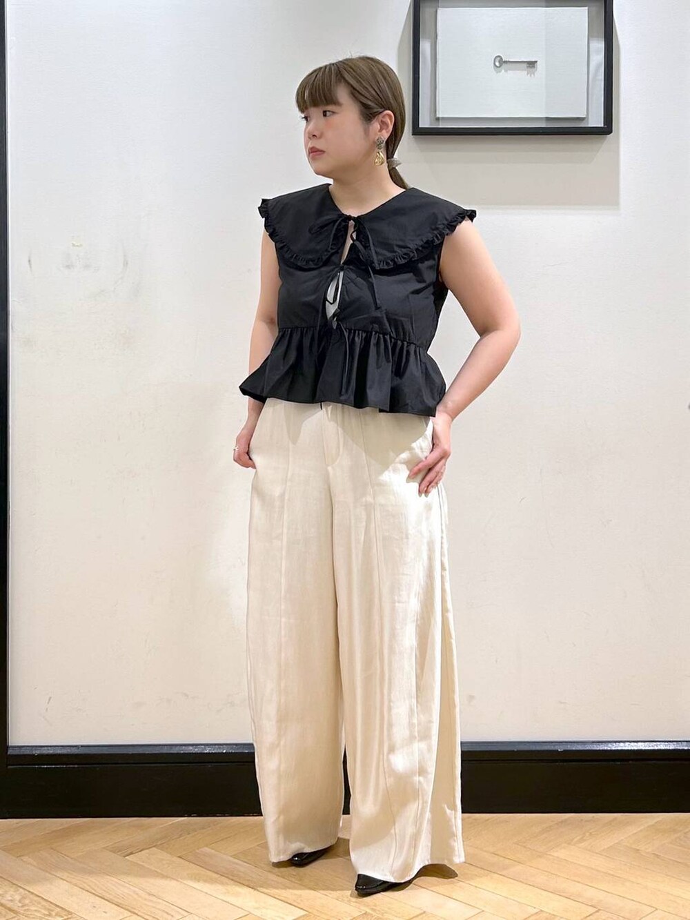 ブラック系のパンプス、ブラック系のシャツ/ブラウス、ホワイト系のキャミソールを着用したレディースの夏コーディネートの2枚目の写真