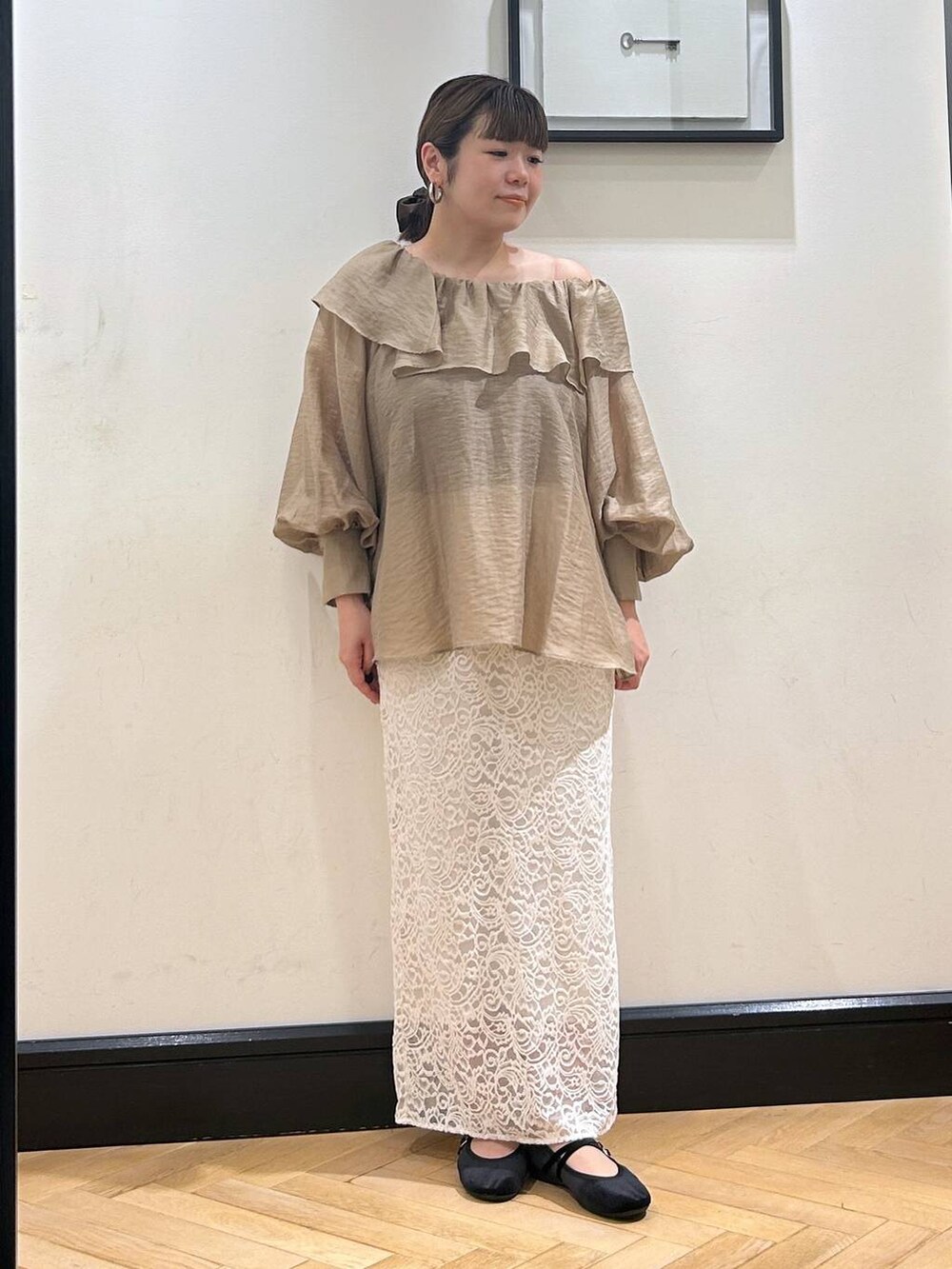 ホワイト系のスカート、ブラック系のバレエシューズを着用したレディースの秋コーディネートの2枚目の写真