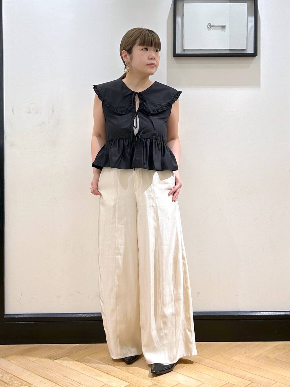 ブラック系のパンプス、ブラック系のシャツ/ブラウス、ホワイト系のキャミソールを着用したレディースの夏コーディネートの3枚目の写真