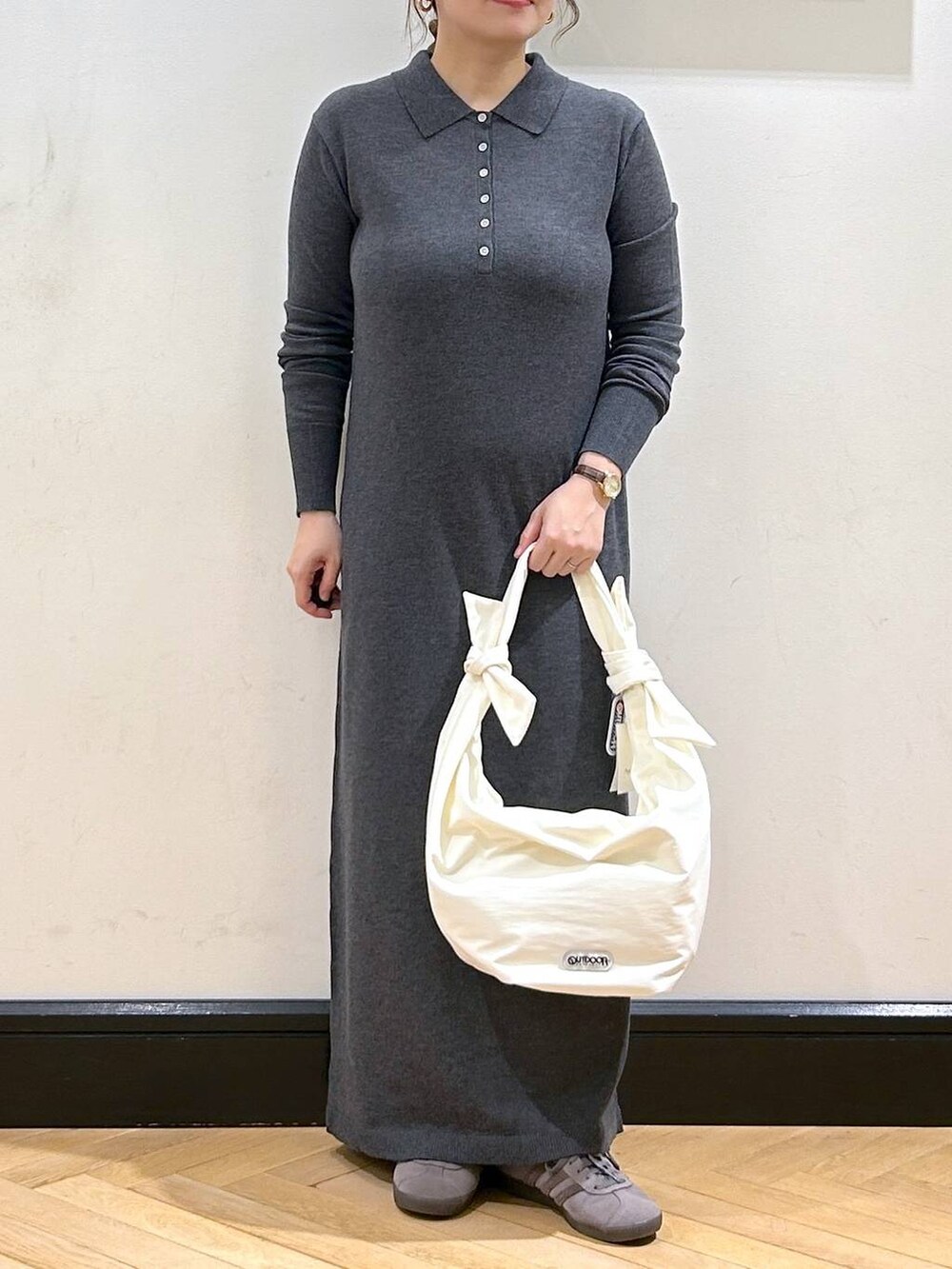 グレー系のスニーカー、ホワイト系のトートバッグ、グレー系のワンピースを着用したレディースの秋コーディネートの2枚目の写真