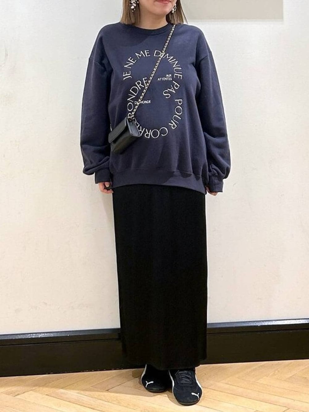 ブラック系のスニーカー、ブラック系のスカート、ブルー系のスウェットを着用したレディースの秋コーディネートの3枚目の写真