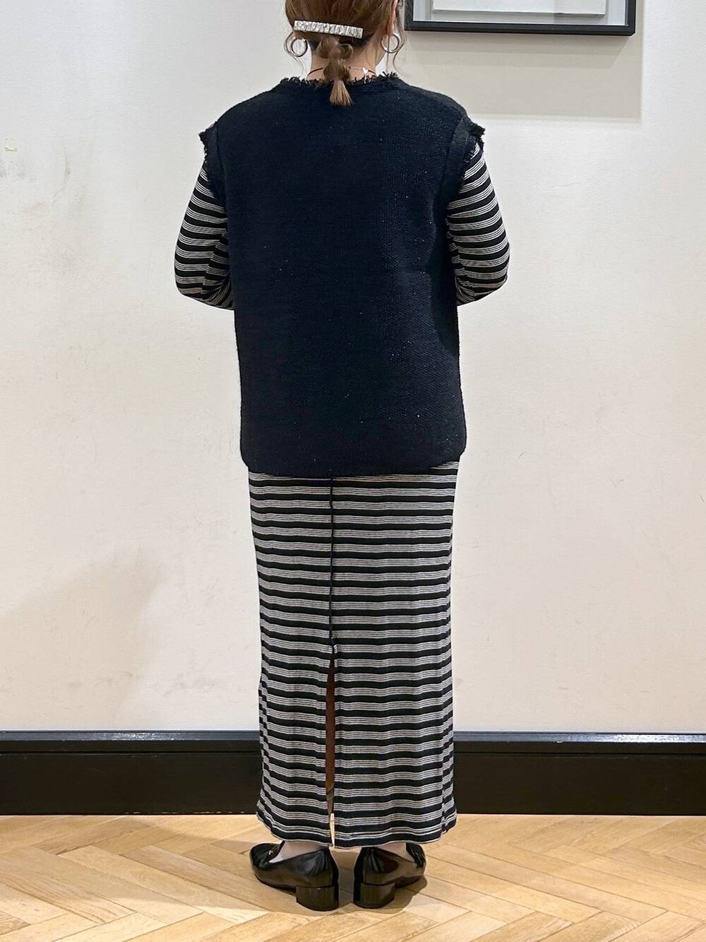 ブルー系のベスト、ブラック系のローファー、ベージュ系のショルダーバッグを着用したレディースの秋コーディネートの6枚目の写真