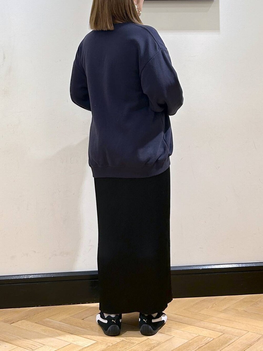 ブラック系のスニーカー、ブラック系のスカート、ブルー系のスウェットを着用したレディースの秋コーディネートの8枚目の写真