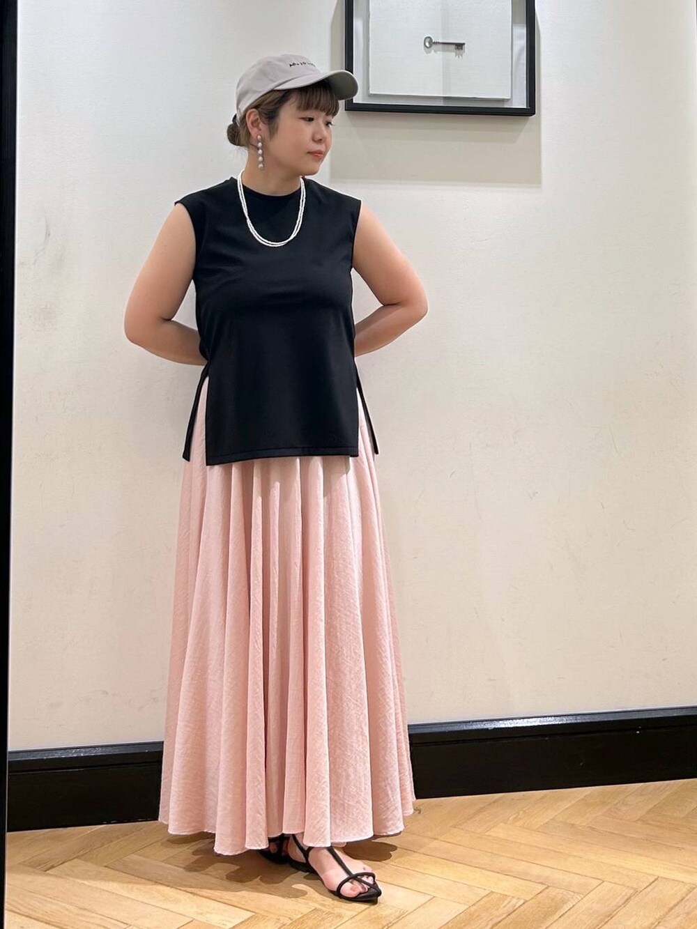 ブラウン系のサンダル、ブラック系のTシャツ/カットソー、ピンク系のスカートを着用したレディースの夏コーディネートの6枚目の写真