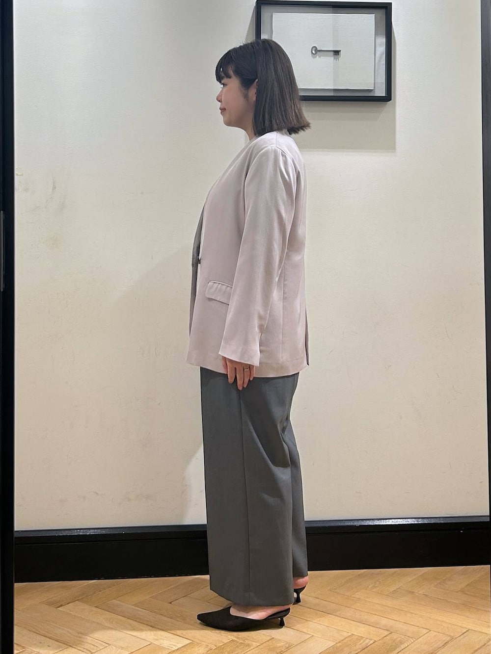 ブラウン系のパンプス、グレー系のノーカラージャケット、ブラック系のショルダーバッグを着用したレディースの夏コーディネートの6枚目の写真