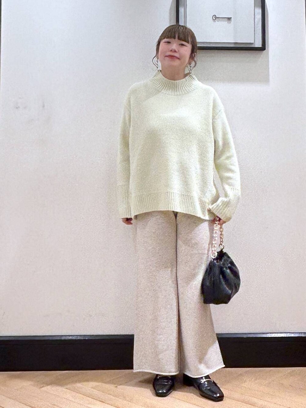 ブラック系のローファー、イエロー系のニット/セーター、ブラック系のショルダーバッグを着用したレディースの冬コーディネートの3枚目の写真