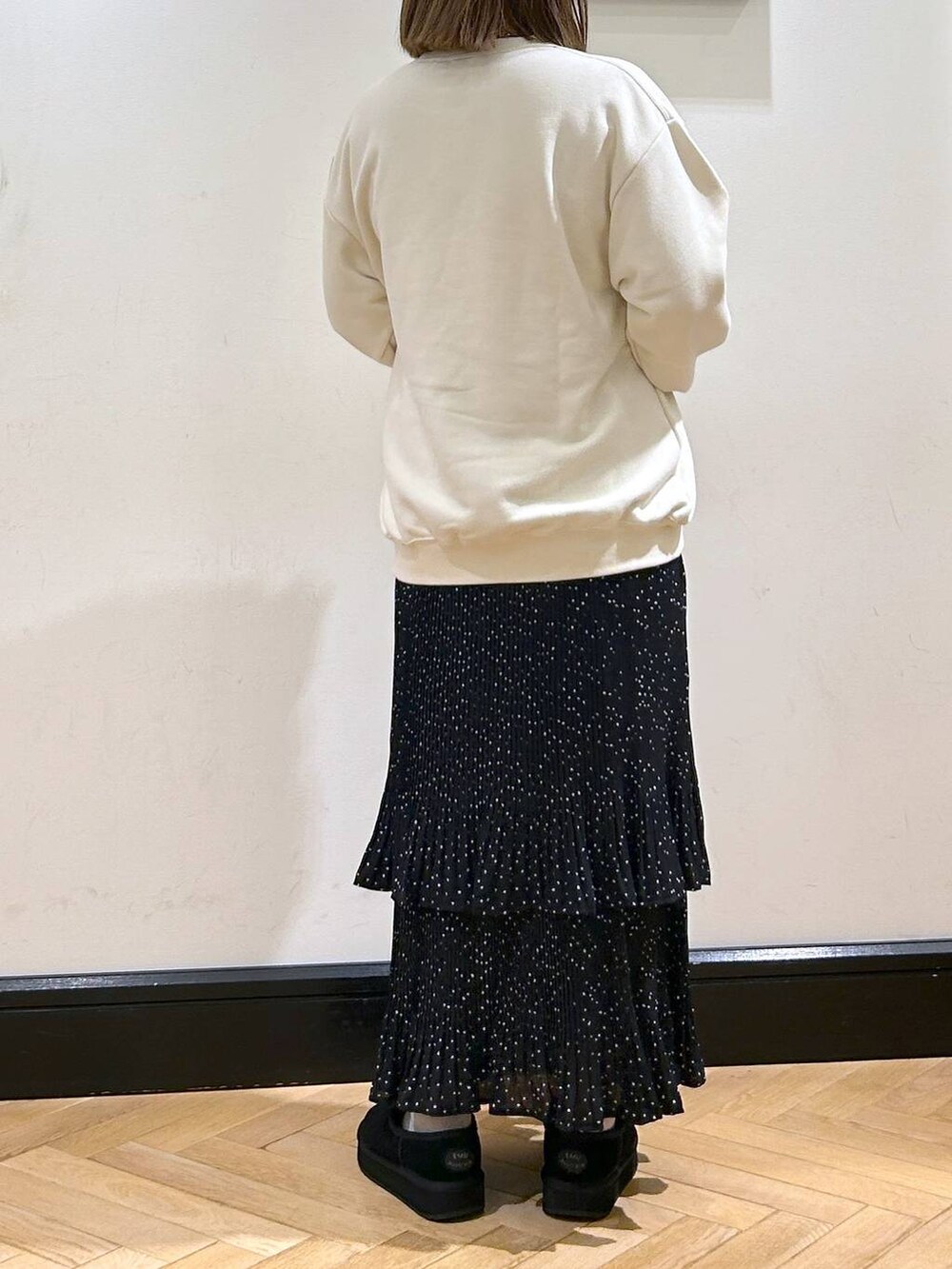 グレー系のスカート、ホワイト系のスウェット、ブラック系のスリッポンを着用したレディースの秋コーディネートの7枚目の写真