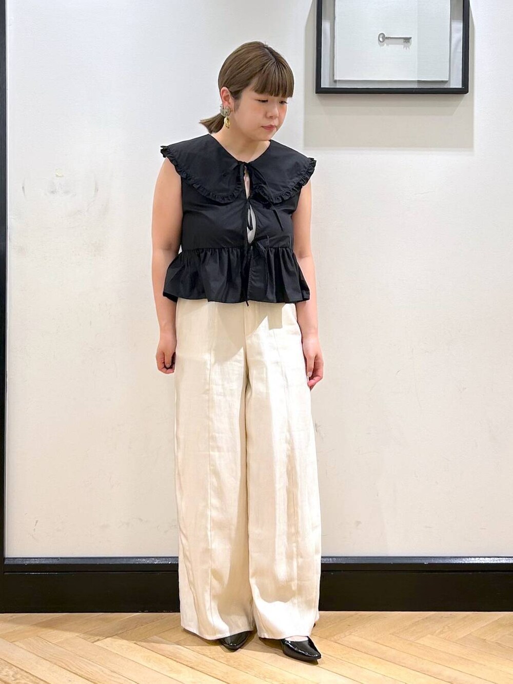 ブラック系のパンプス、ブラック系のシャツ/ブラウス、ホワイト系のキャミソールを着用したレディースの夏コーディネートの4枚目の写真