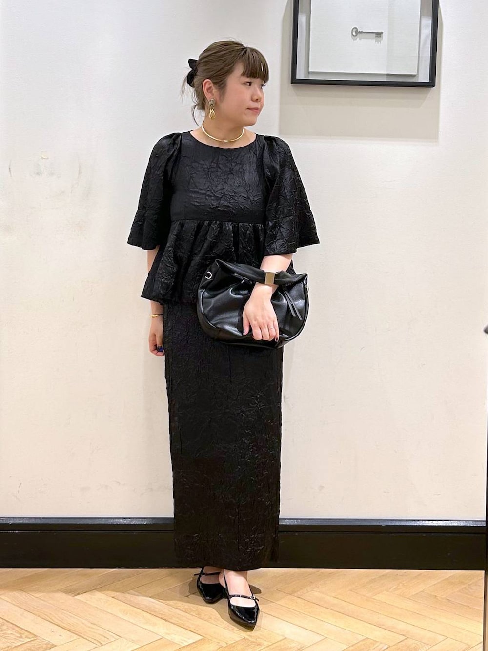 ブラック系のハンドバッグ、ブラック系のパンプス、ブラック系のワンピースを着用したレディースの夏コーディネートの2枚目の写真
