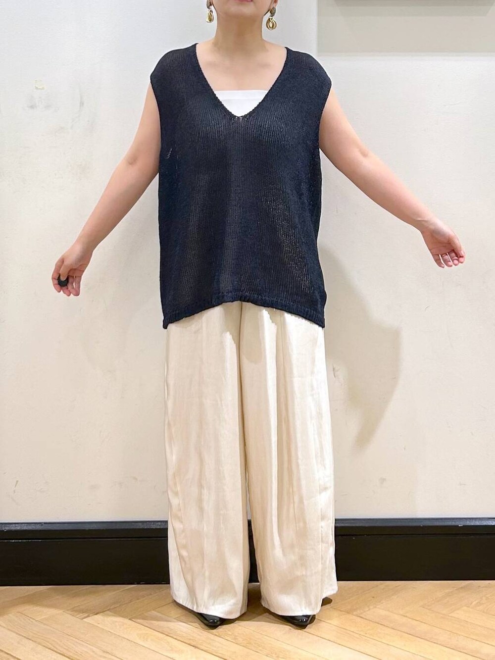 ブラック系のパンプス、ホワイト系のタンクトップ、ブラック系のボストンバッグを着用したレディースの夏コーディネートの8枚目の写真