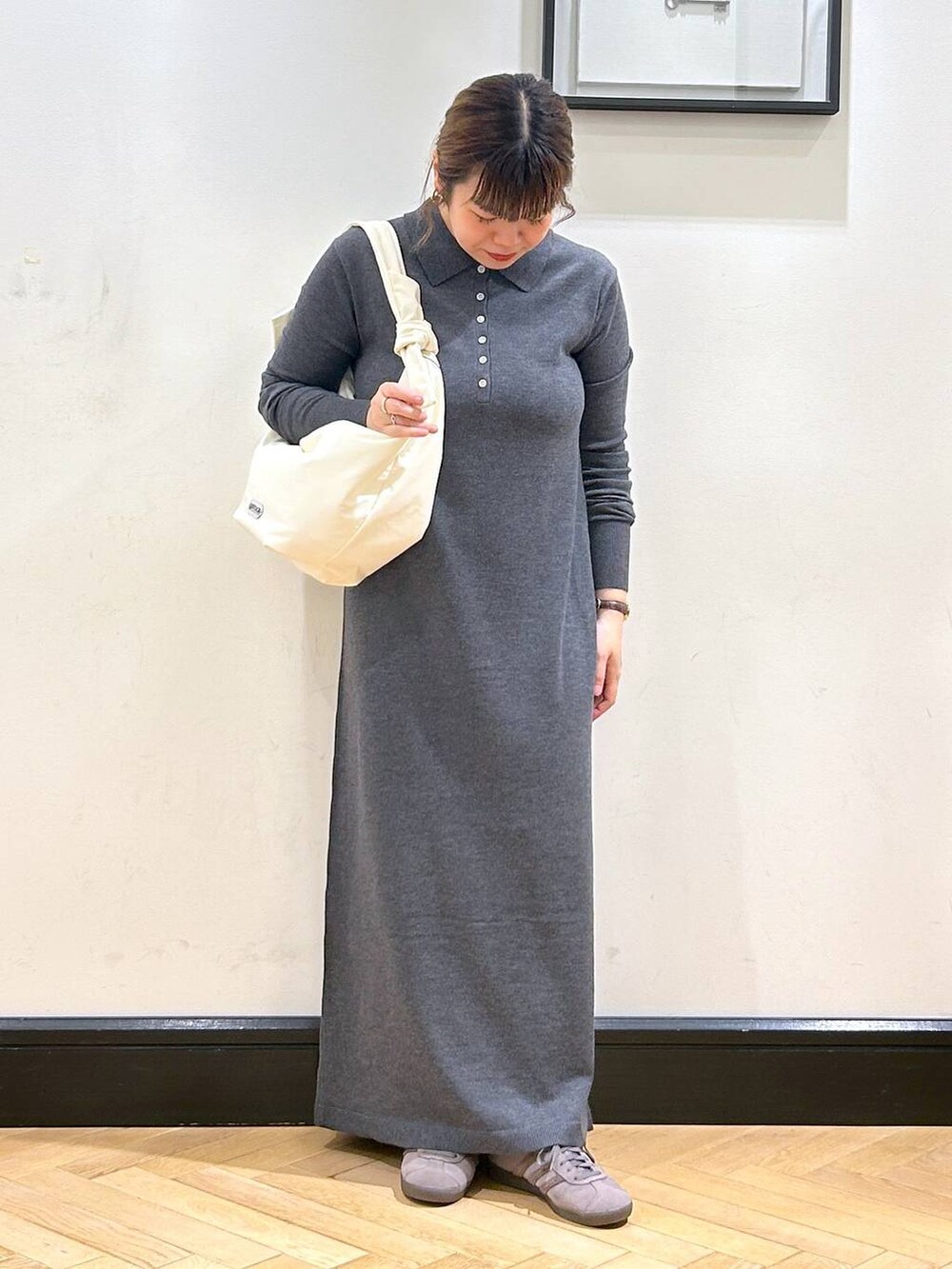 グレー系のスニーカー、ホワイト系のトートバッグ、グレー系のワンピースを着用したレディースの秋コーディネートの4枚目の写真