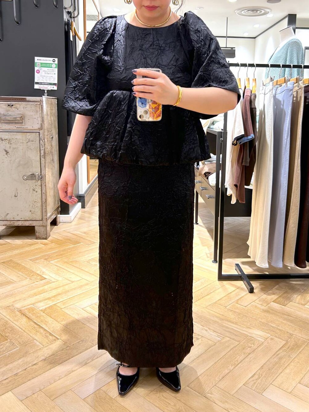 ブラック系のハンドバッグ、ブラック系のパンプス、ブラック系のワンピースを着用したレディースの夏コーディネートの9枚目の写真