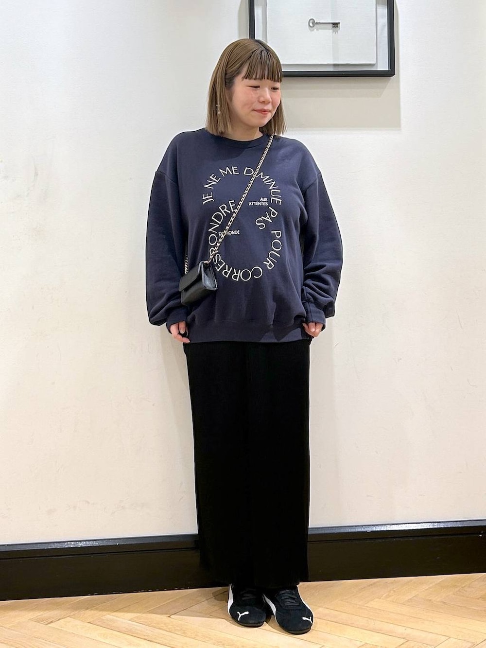 ブラック系のスニーカー、ブラック系のスカート、ブルー系のスウェットを着用したレディースの秋コーディネートの4枚目の写真