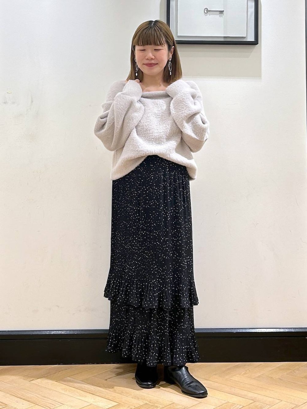 グレー系のスカート、ブラック系のブーツ、グレー系のニット/セーターを着用したレディースの冬コーディネートの7枚目の写真