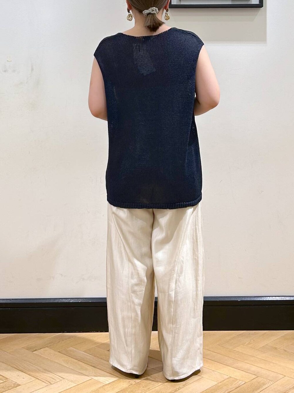 ブラック系のパンプス、ホワイト系のタンクトップ、ブラック系のボストンバッグを着用したレディースの夏コーディネートの9枚目の写真