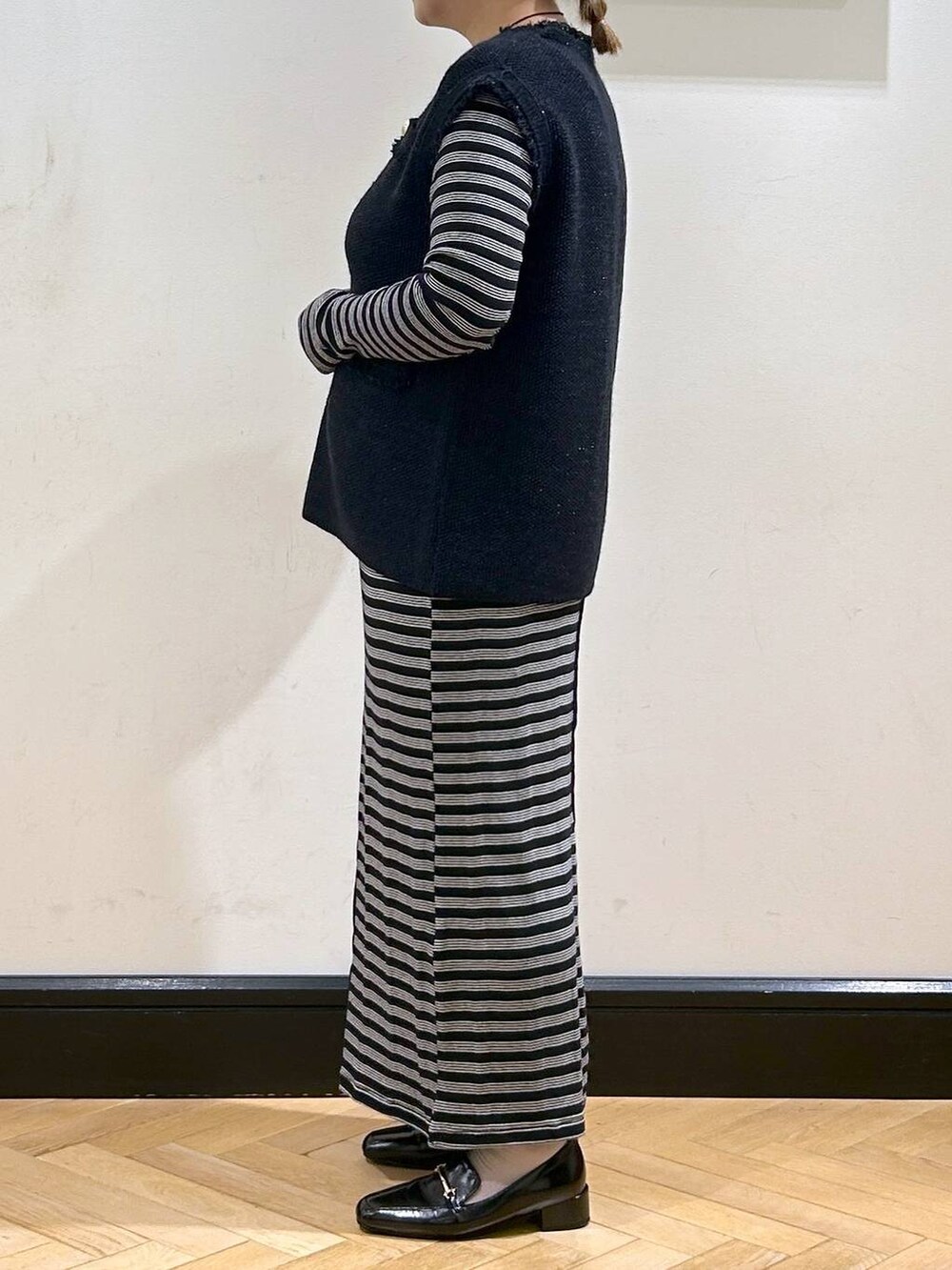 ブルー系のベスト、ブラック系のローファー、ベージュ系のショルダーバッグを着用したレディースの秋コーディネートの5枚目の写真