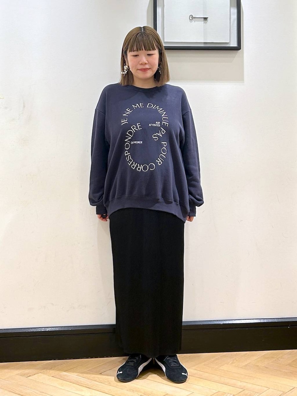 ブラック系のスニーカー、ブラック系のスカート、ブルー系のスウェットを着用したレディースの秋コーディネートの5枚目の写真