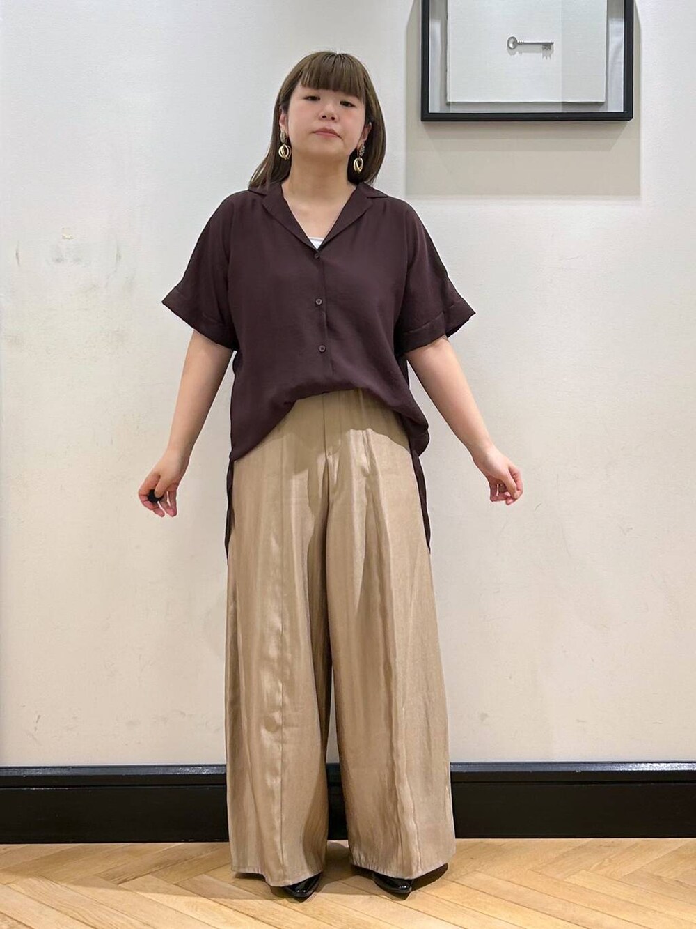 ブラウン系のシャツ/ブラウス、ブラック系のパンプス、ブラック系のハンドバッグを着用したレディースの夏コーディネートの3枚目の写真