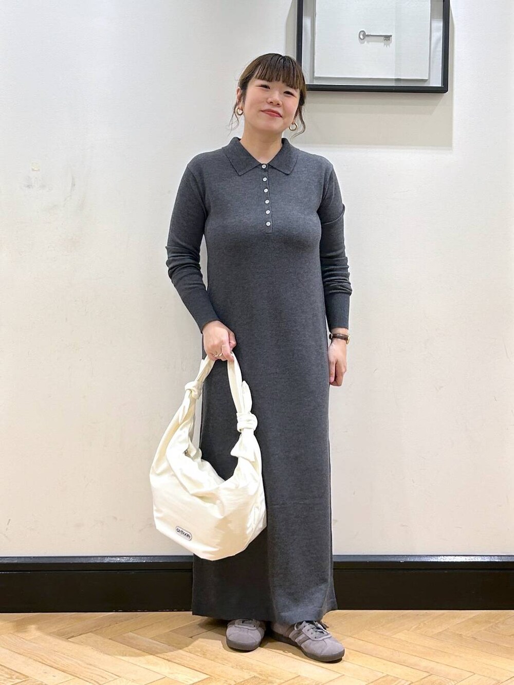 グレー系のスニーカー、ホワイト系のトートバッグ、グレー系のワンピースを着用したレディースの秋コーディネートの3枚目の写真