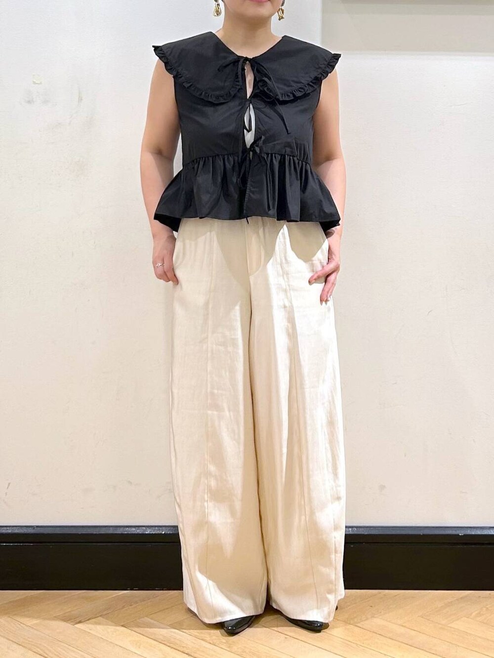 ブラック系のパンプス、ブラック系のシャツ/ブラウス、ホワイト系のキャミソールを着用したレディースの夏コーディネートの7枚目の写真