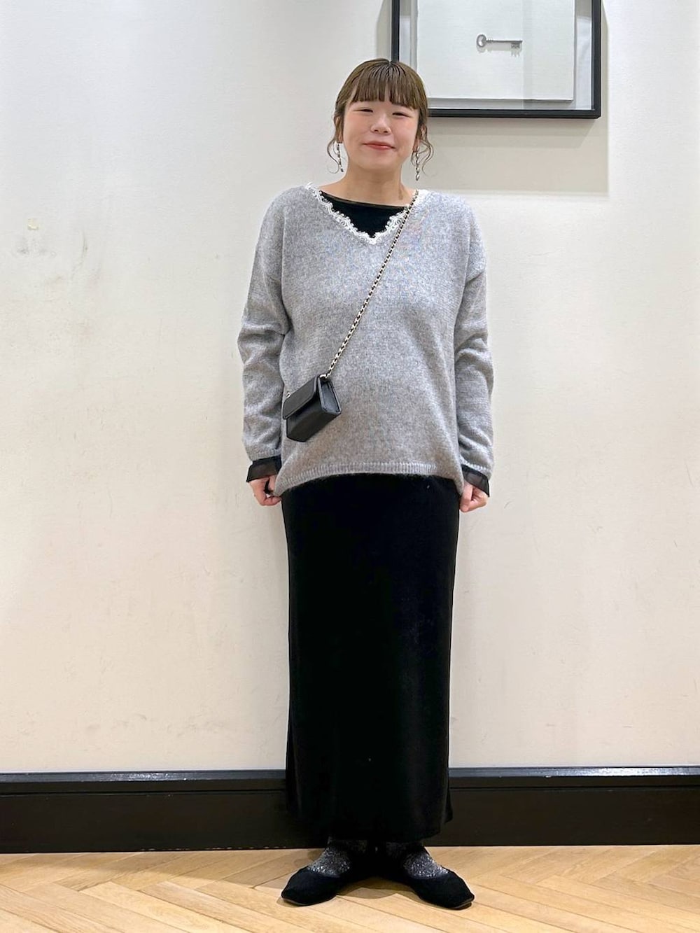 グレー系のニット/セーター、ブラック系のワンピースを着用したレディースの冬コーディネートの4枚目の写真