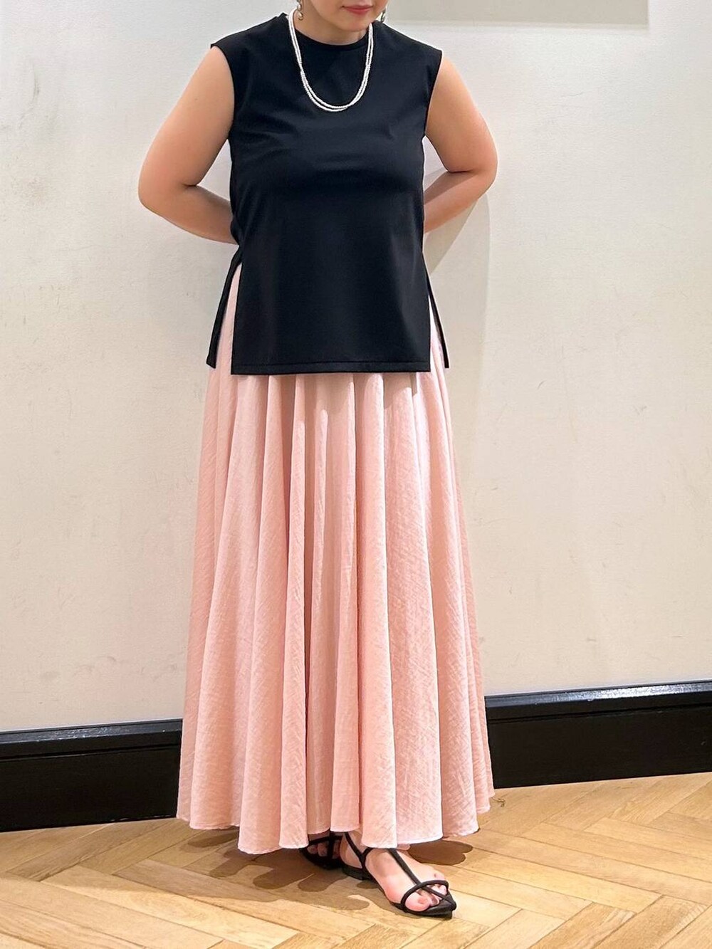 ブラウン系のサンダル、ブラック系のTシャツ/カットソー、ピンク系のスカートを着用したレディースの夏コーディネートの5枚目の写真