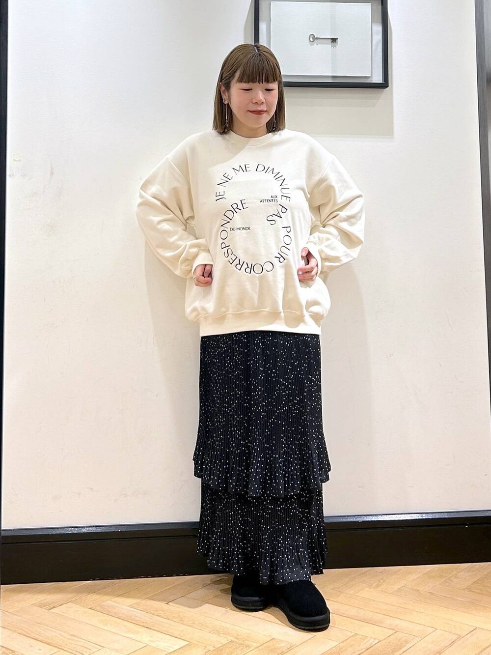 グレー系のスカート、ホワイト系のスウェット、ブラック系のスリッポンを着用したレディースの秋コーディネートの3枚目の写真