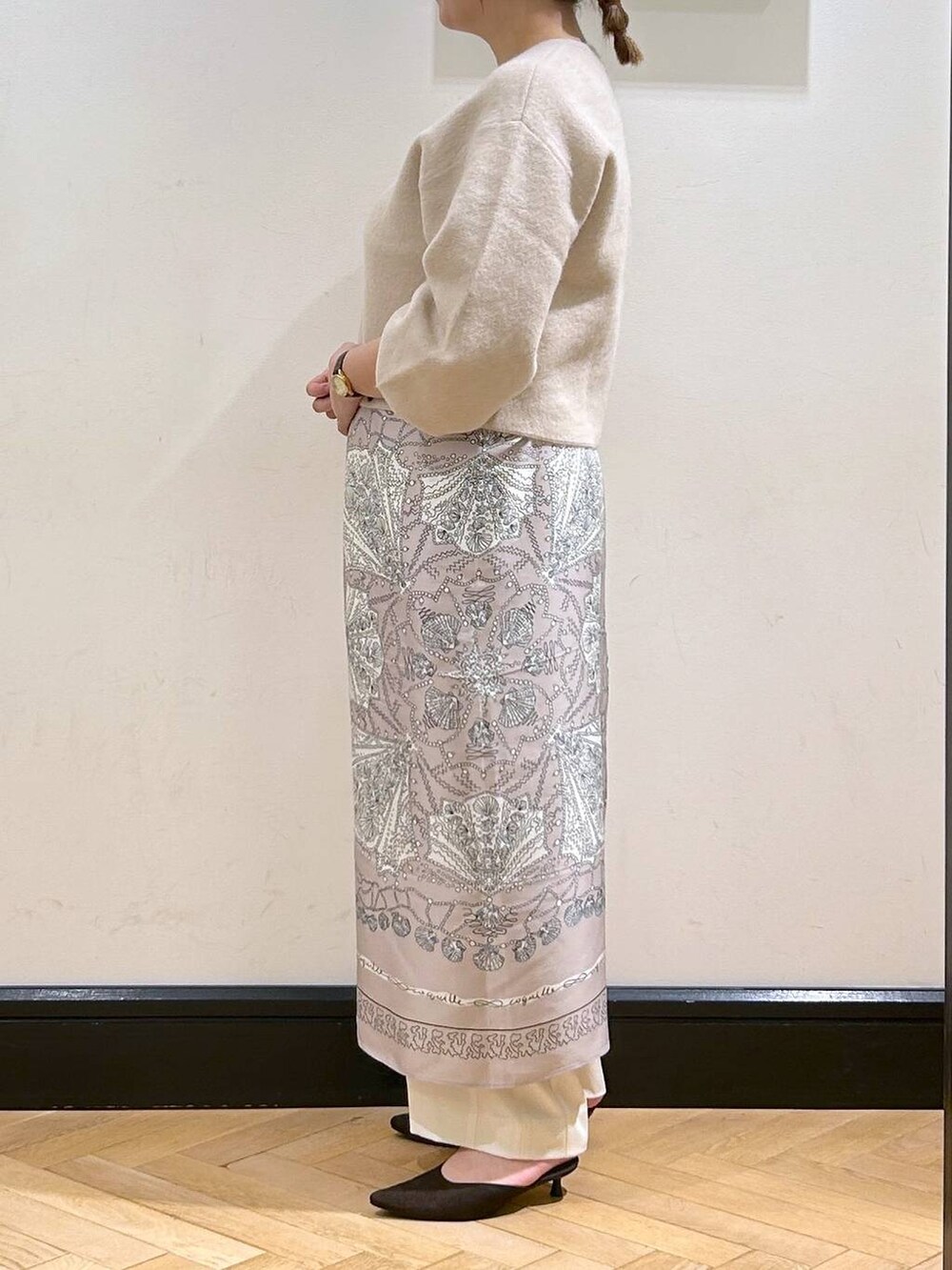 ホワイト系のスラックス、ホワイト系のカーディガン/ボレロ、ブラウン系のパンプスを着用したレディースの秋コーディネートの5枚目の写真