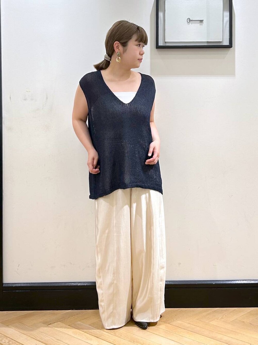 ブラック系のパンプス、ホワイト系のタンクトップ、ブラック系のボストンバッグを着用したレディースの夏コーディネートの5枚目の写真