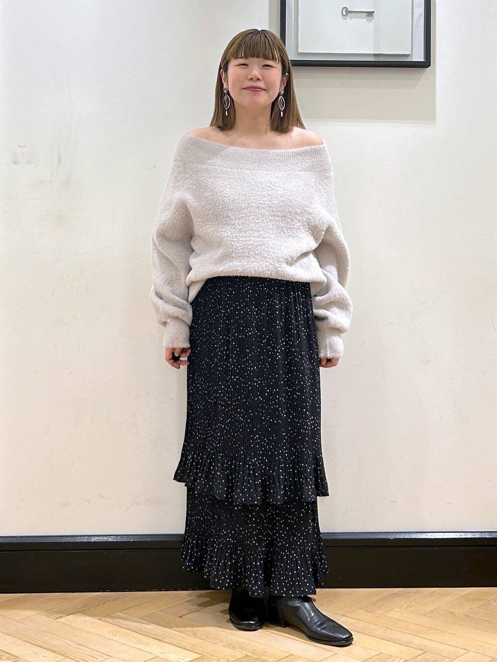 グレー系のスカート、ブラック系のブーツ、グレー系のニット/セーターを着用したレディースの冬コーディネートの8枚目の写真