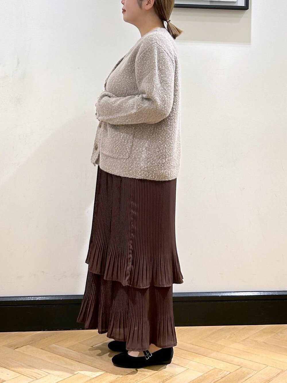 ブラウン系のスカート、ベージュ系のカーディガン/ボレロ、ブラック系のバレエシューズを着用したレディースの秋コーディネートの8枚目の写真