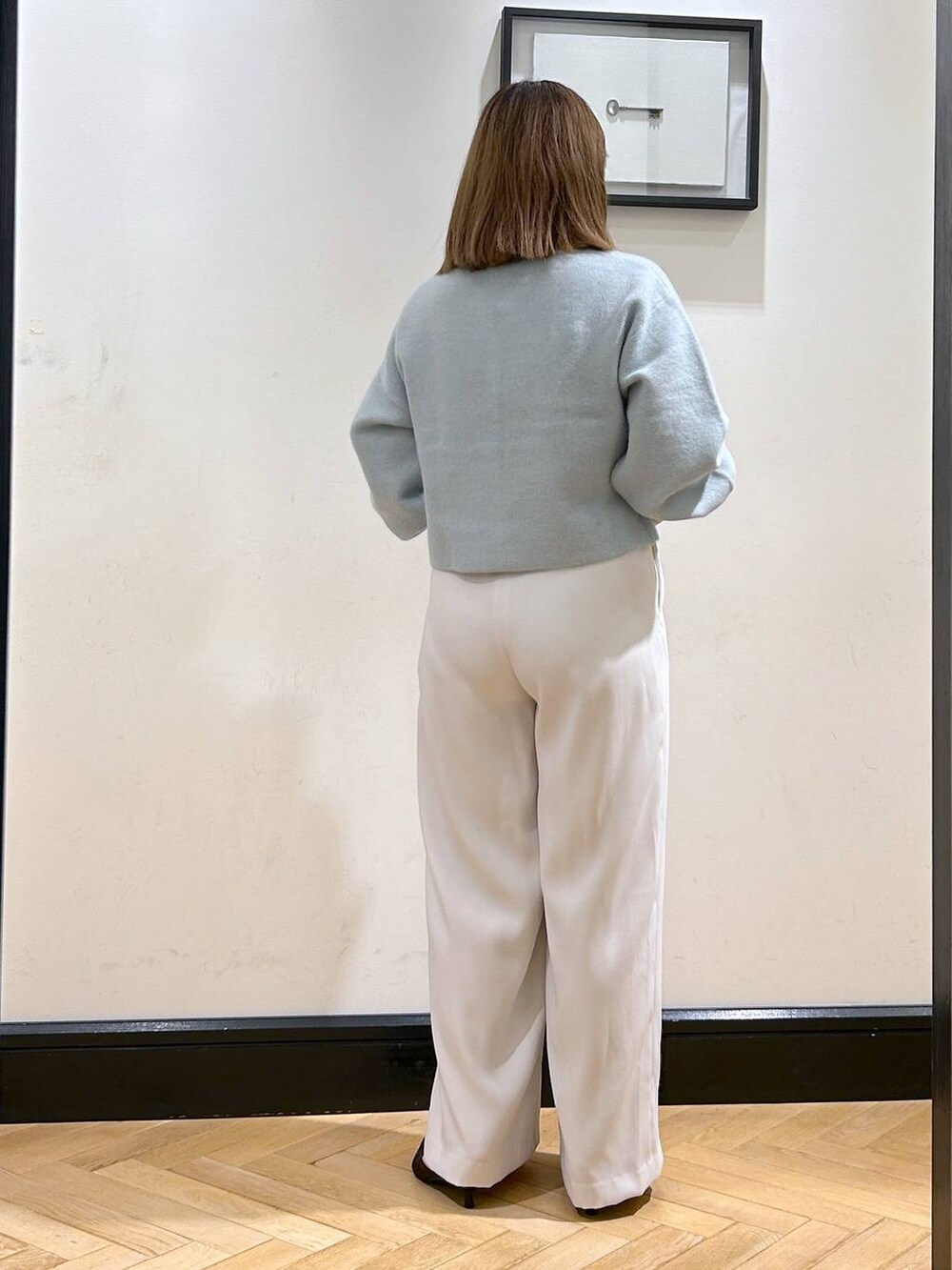 グリーン系のカーディガン/ボレロ、ホワイト系のスラックス、ブラウン系のパンプスを着用したレディースの秋コーディネートの6枚目の写真