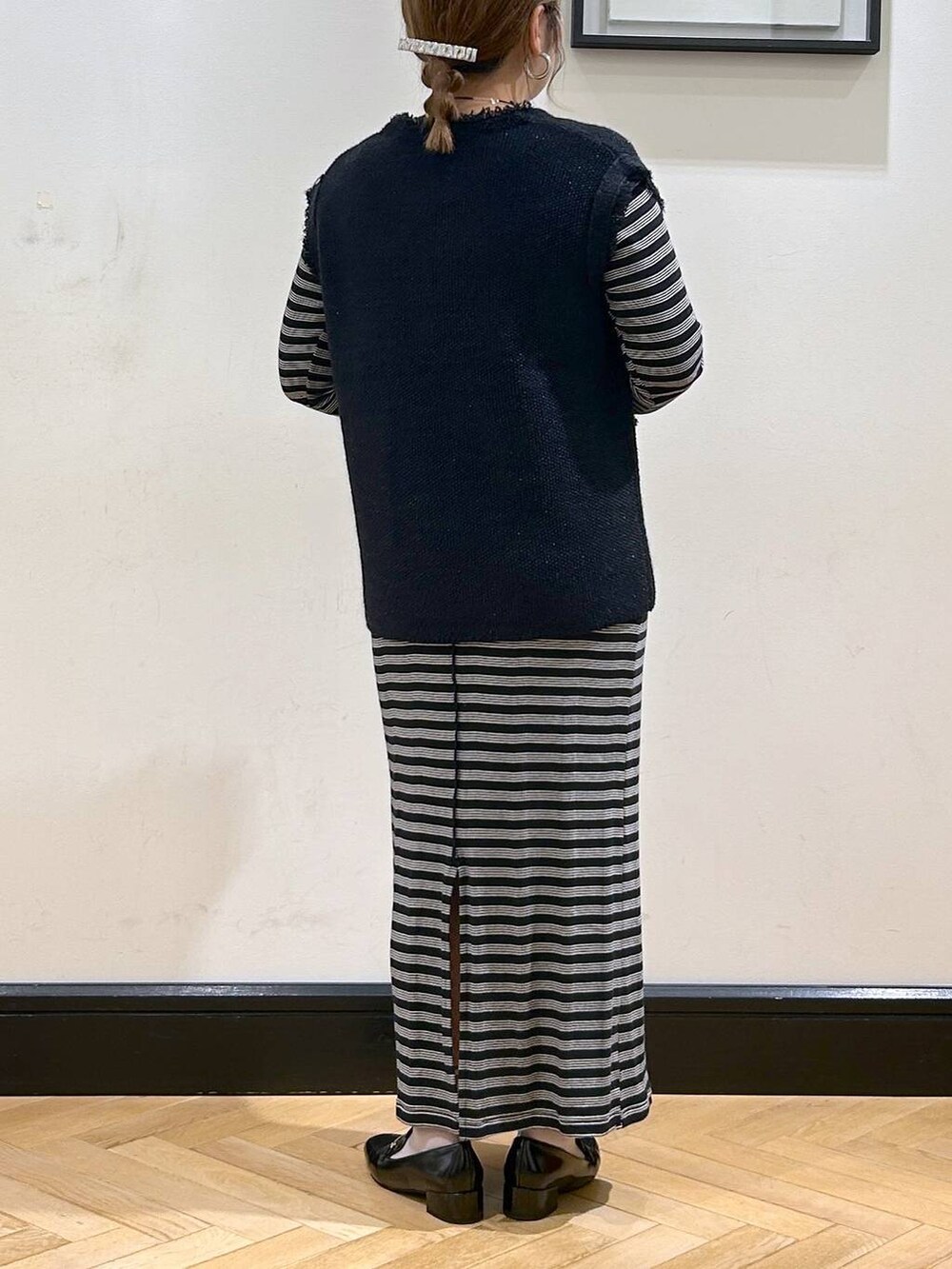 ブルー系のベスト、ブラック系のローファー、ベージュ系のショルダーバッグを着用したレディースの秋コーディネートの7枚目の写真