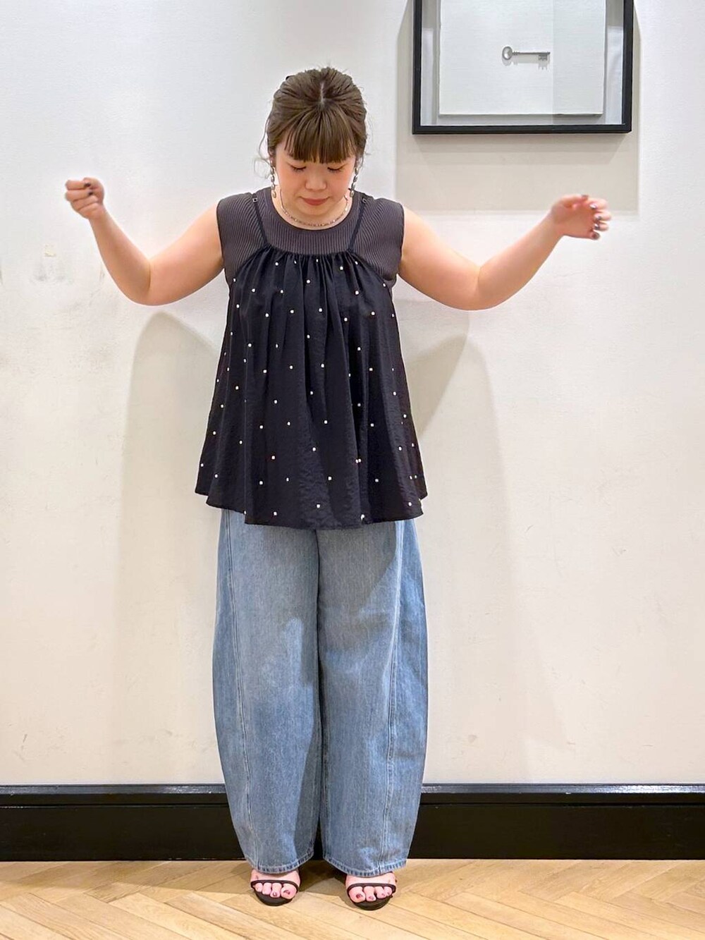 ブルー系のデニムパンツ、ブラウン系のサンダル、グレー系のタンクトップを着用したレディースの夏コーディネートの4枚目の写真