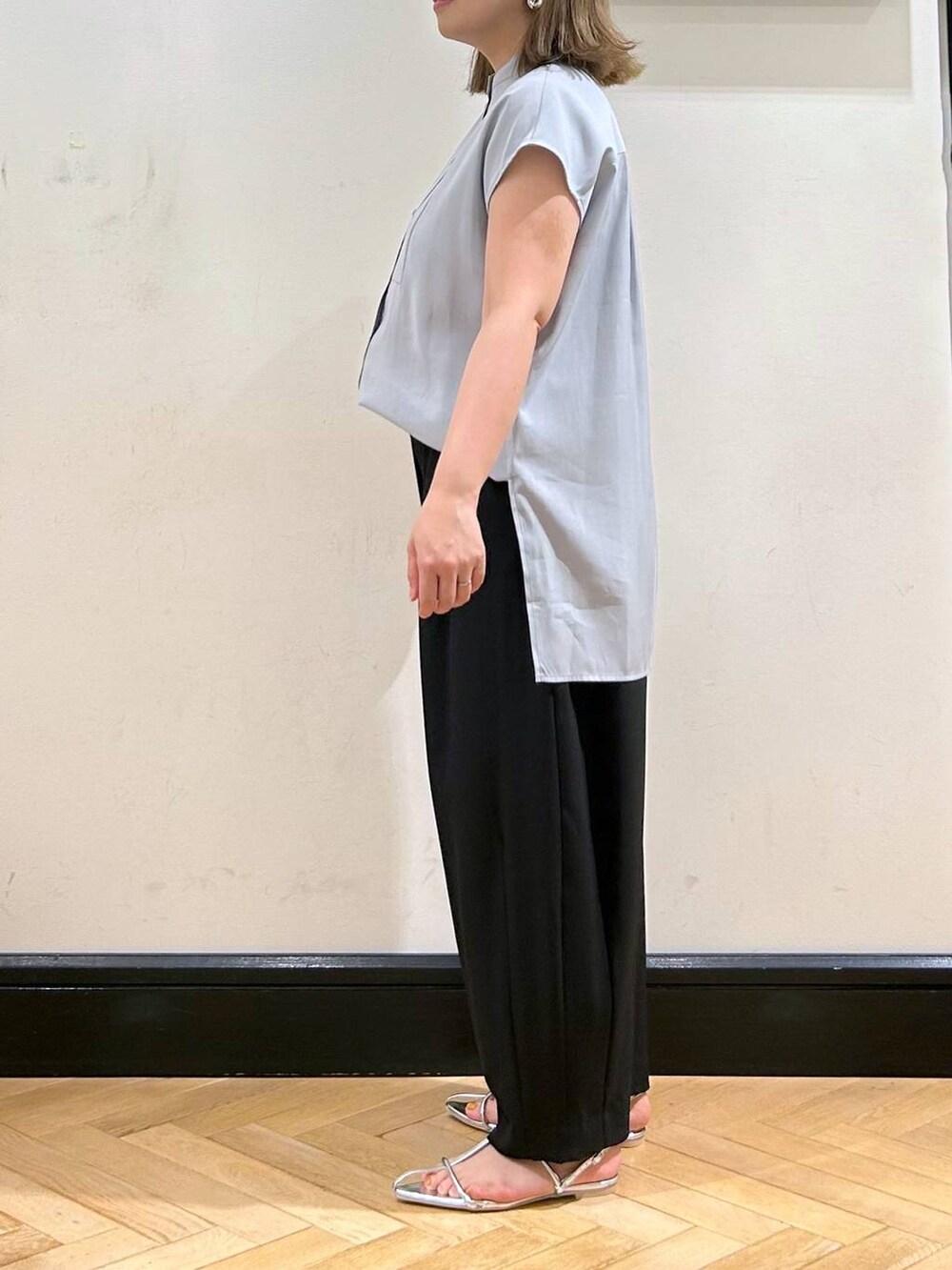 シルバー系のサンダル、ブラック系のスラックス、ブラック系のショルダーバッグを着用したレディースの夏コーディネートの5枚目の写真