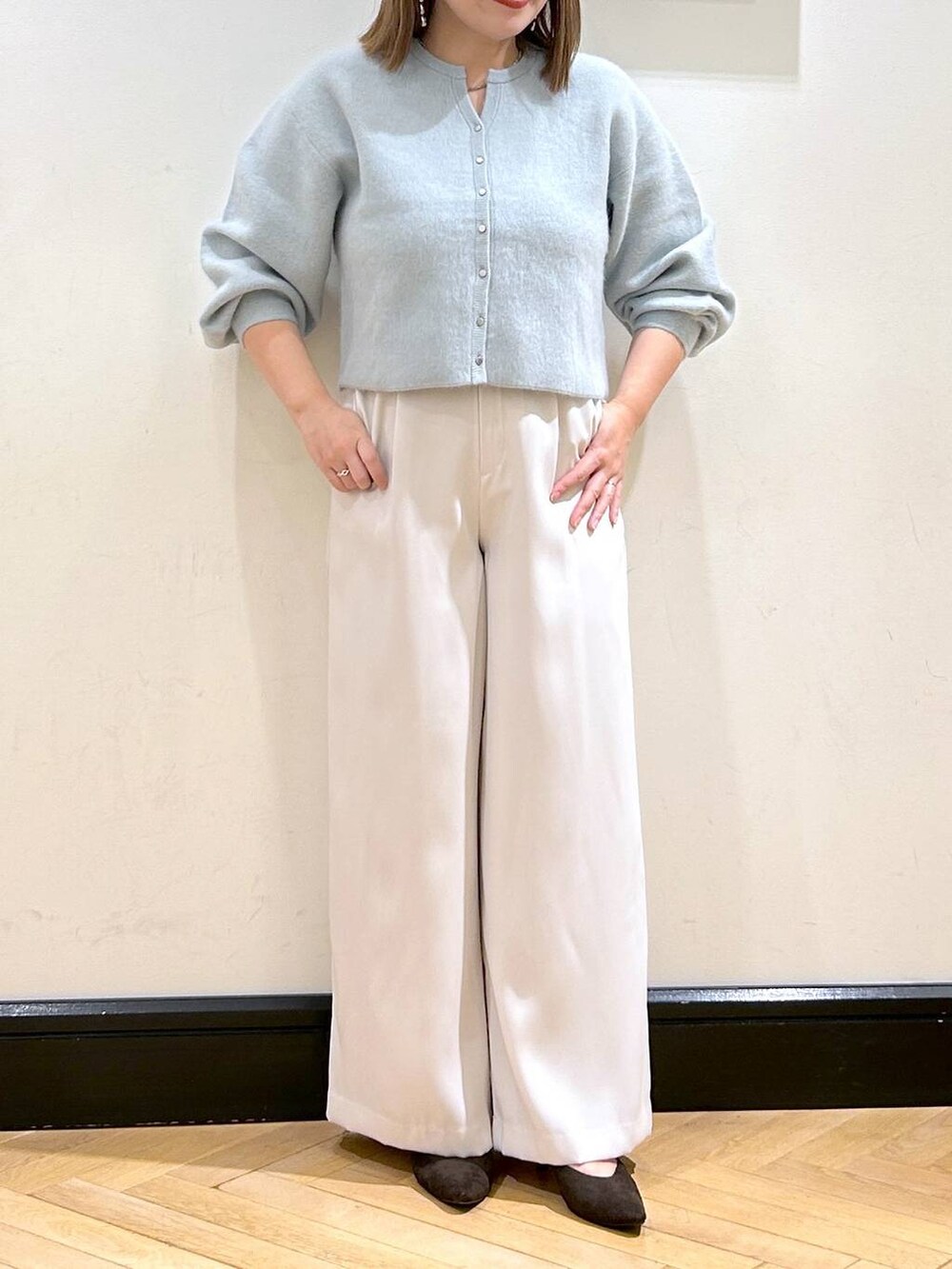 グリーン系のカーディガン/ボレロ、ホワイト系のスラックス、ブラウン系のパンプスを着用したレディースの秋コーディネートの7枚目の写真