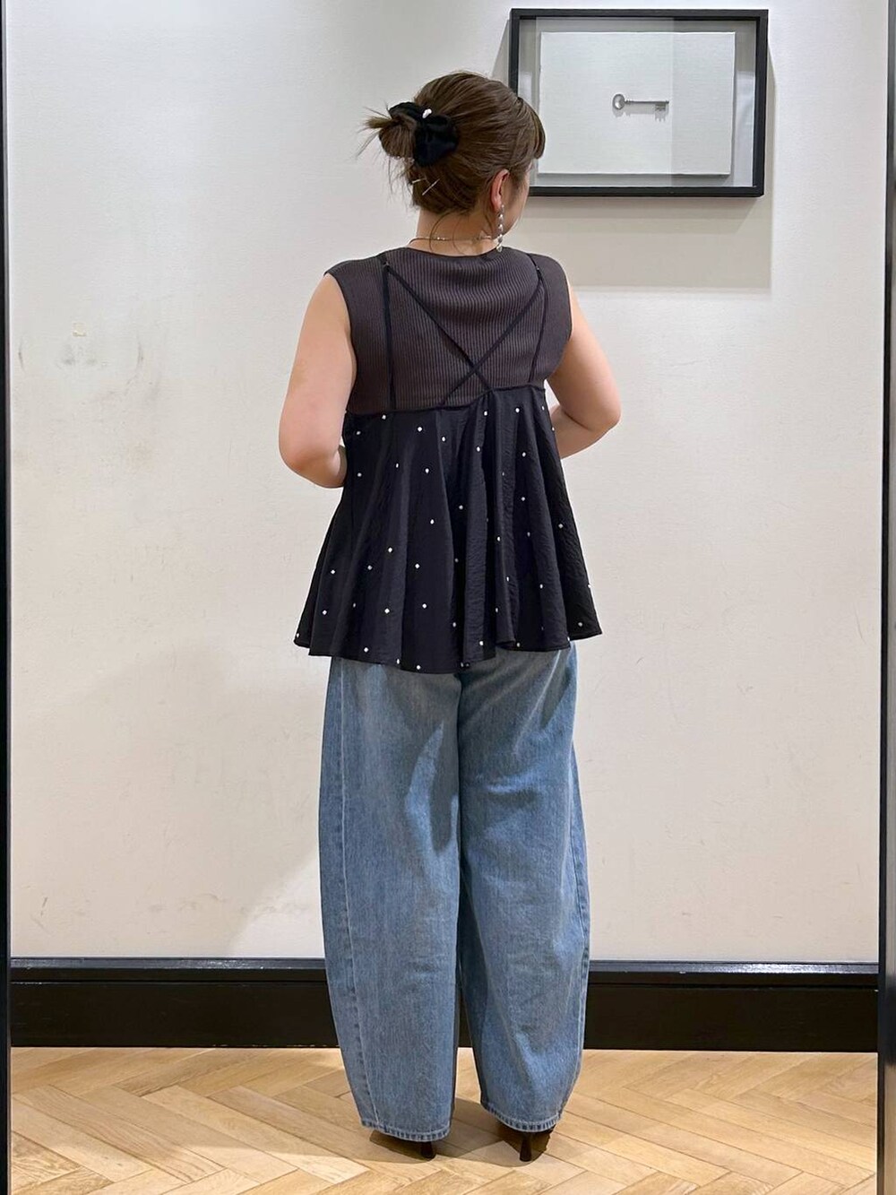 ブルー系のデニムパンツ、ブラウン系のサンダル、グレー系のタンクトップを着用したレディースの夏コーディネートの7枚目の写真