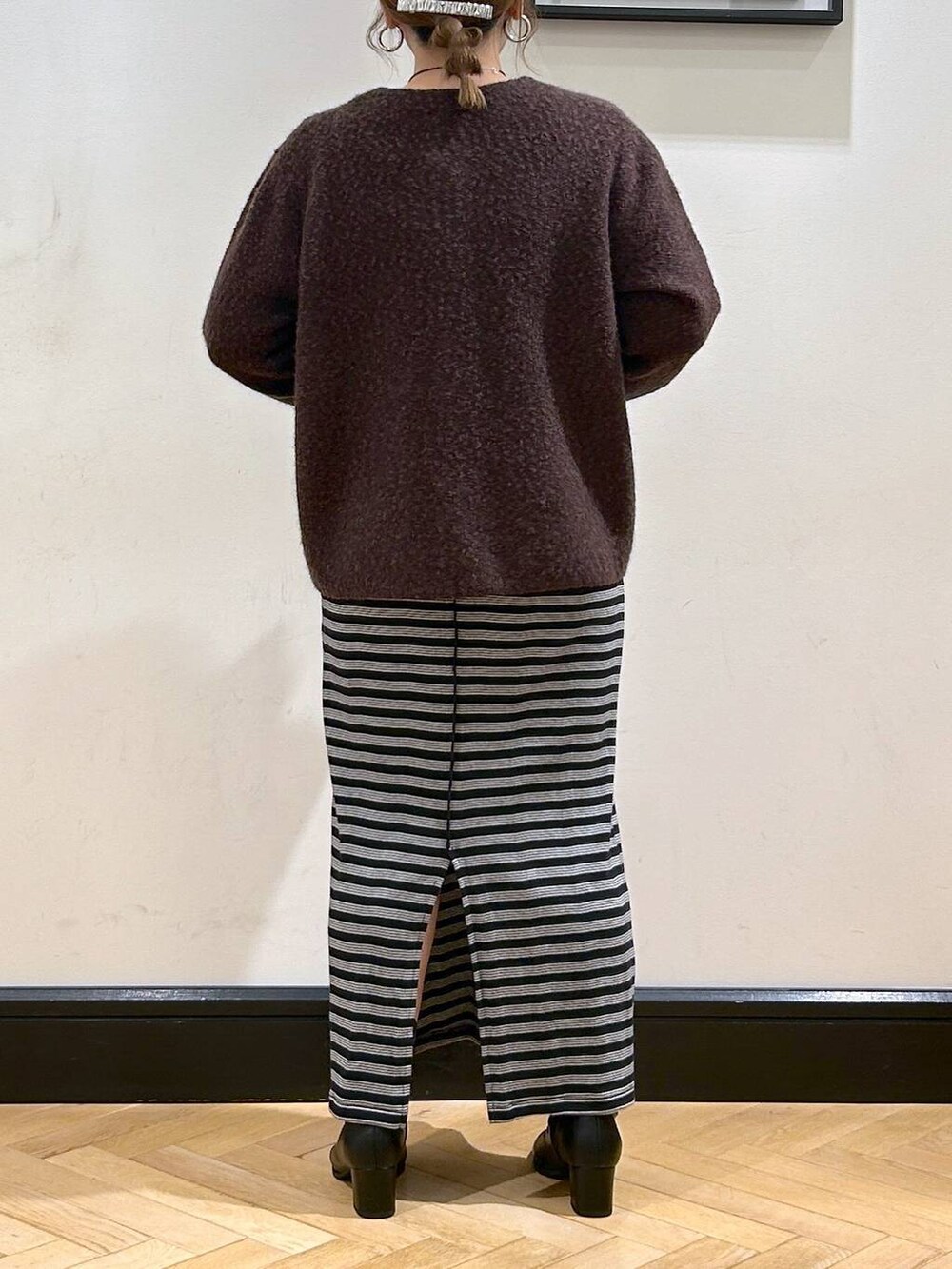 ブラック系のブーツ、ブラック系のワンピース、ブラウン系のカーディガン/ボレロを着用したレディースの秋コーディネートの4枚目の写真