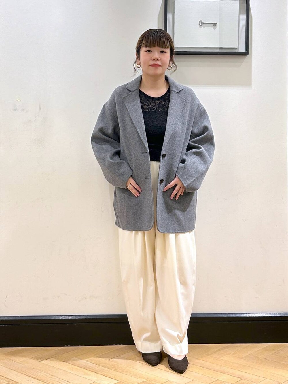 ホワイト系のスラックス、ブラウン系のパンプス、ブラック系のTシャツ/カットソーを着用したレディースの秋コーディネートの2枚目の写真