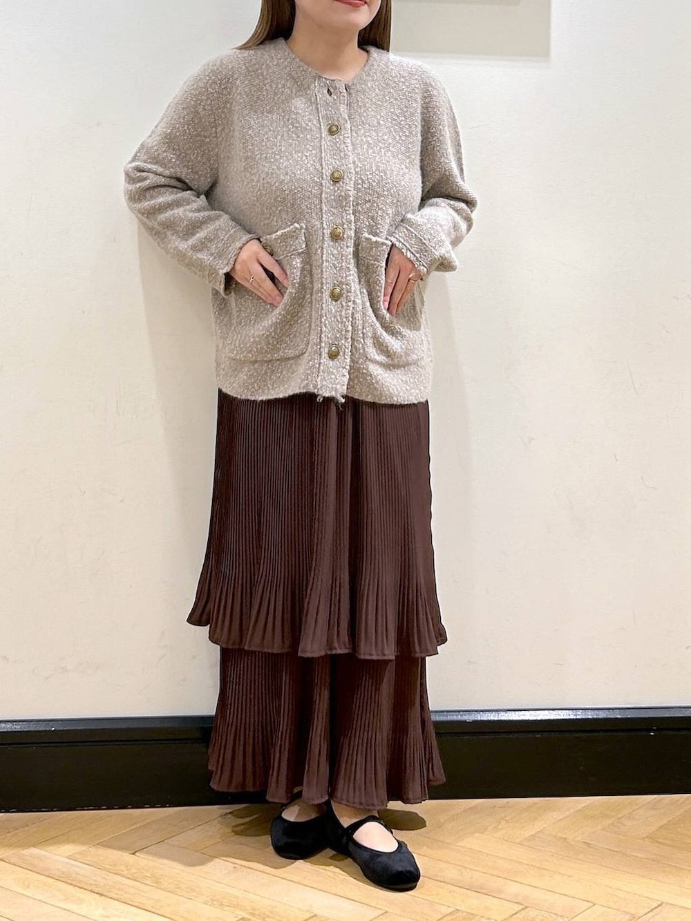ブラウン系のスカート、ベージュ系のカーディガン/ボレロ、ブラック系のバレエシューズを着用したレディースの秋コーディネートの6枚目の写真