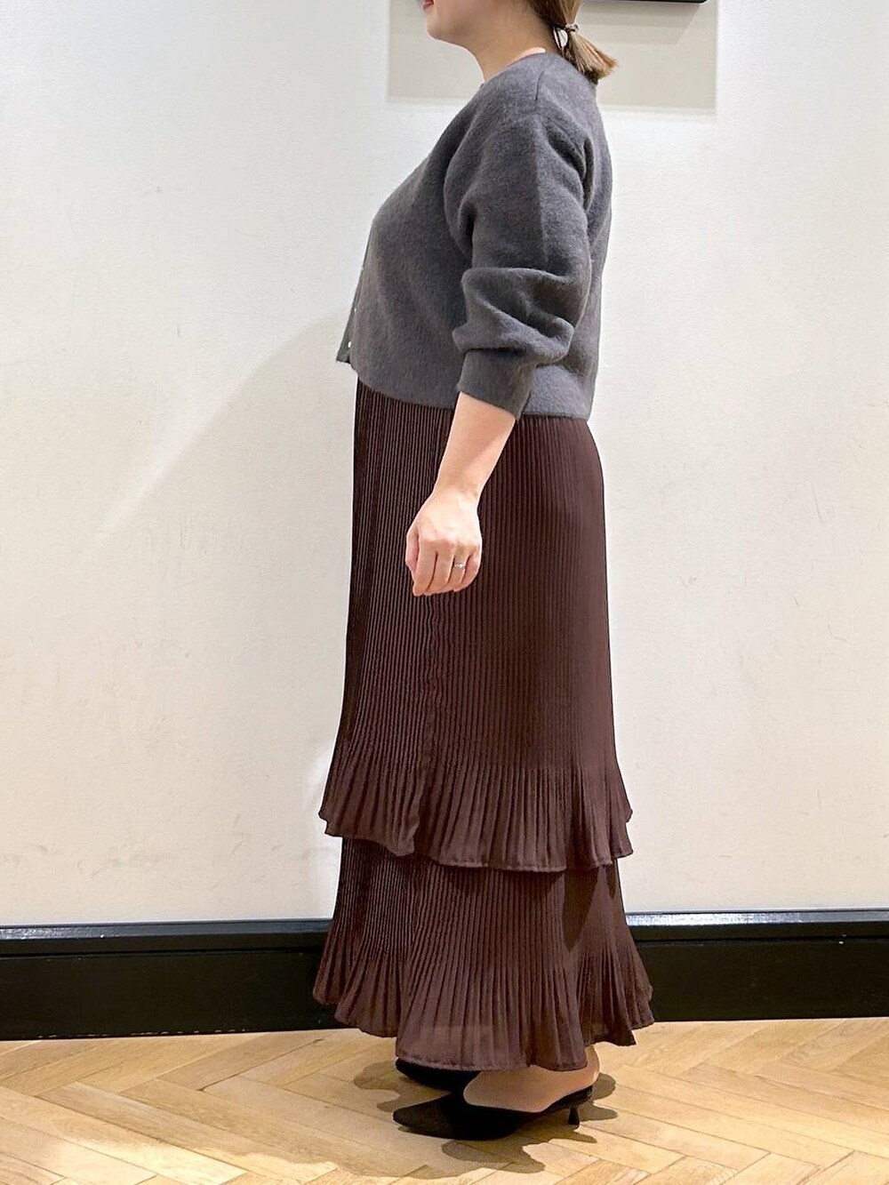 ブラウン系のスカート、グレー系のカーディガン/ボレロ、ブラウン系のパンプスを着用したレディースの秋コーディネートの5枚目の写真