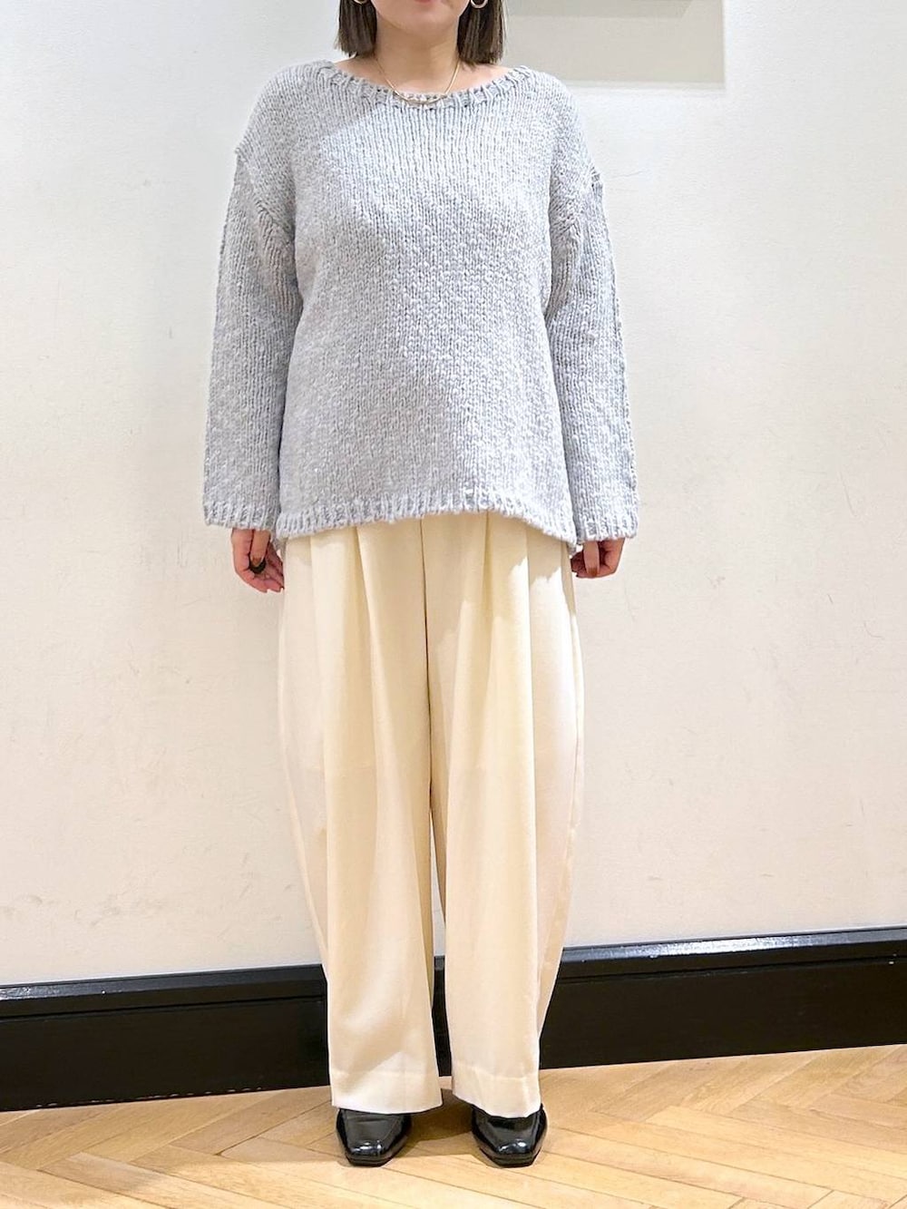 ホワイト系のスラックス、ブラック系のローファー、グレー系のニット/セーターを着用したレディースの秋コーディネートの4枚目の写真