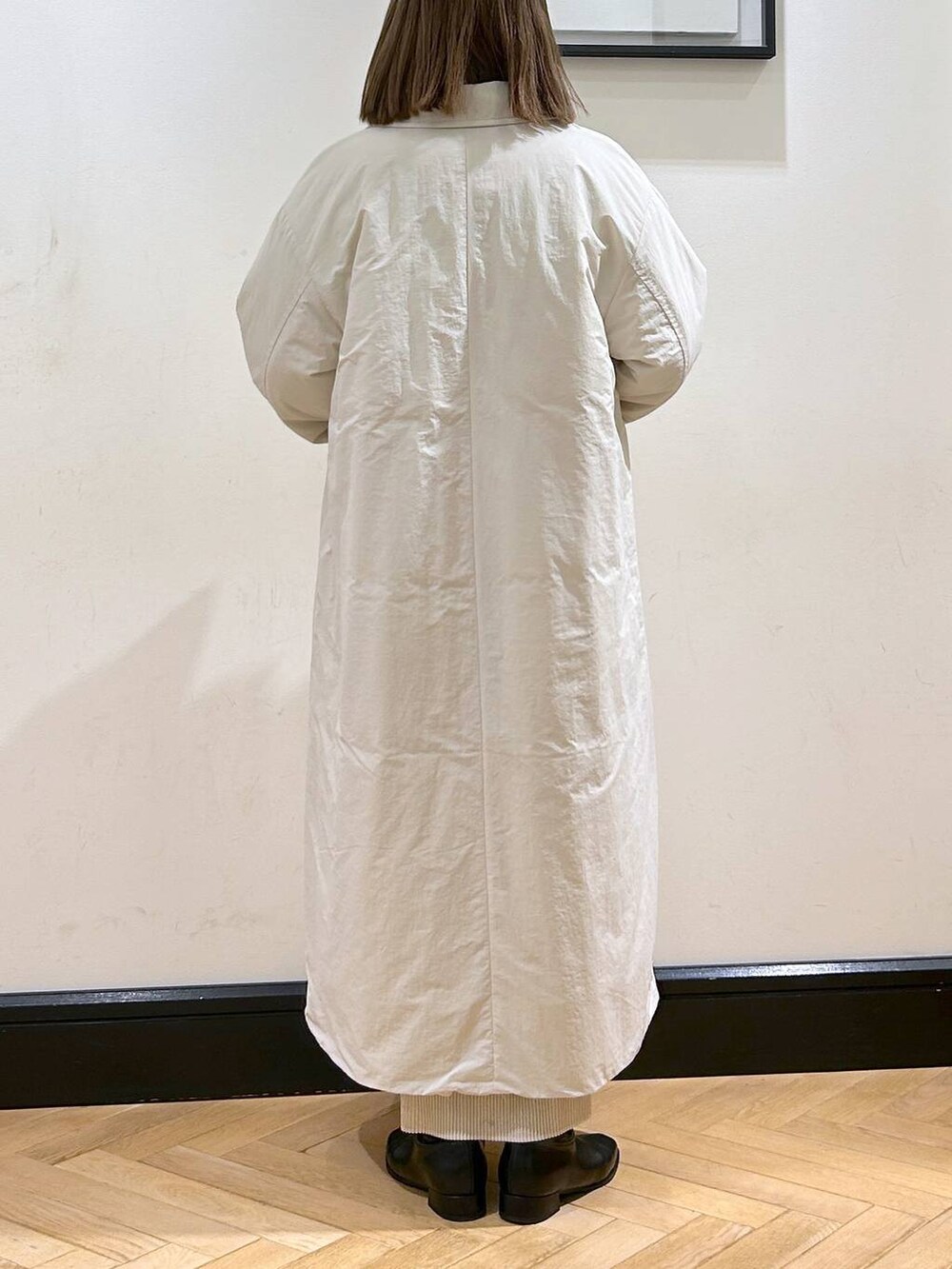 ブルー系のニット/セーター、ホワイト系のスカート、ホワイト系のダウンジャケット/コートを着用したレディースの秋コーディネートの6枚目の写真